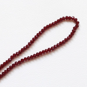 Vue macro de perles en cristal rouge foncé facettées 3,5 mm pour bijoux faits main