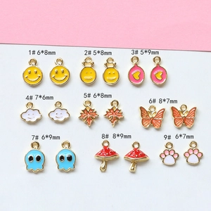 Detail of assorted mini gold-plated charms with colorful enamel for DIY jewelry making