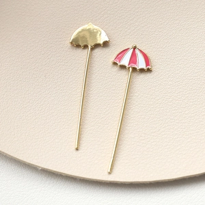 Makroaufnahme von Regenschirm-Anhängern aus Gold mit Emaille für DIY-Schmuckdesign