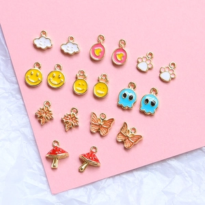 Macro detail of assorted colorful gold-plated enamel charms including smiles and clouds