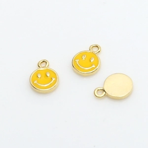 Close-up of mini gold-plated yellow enamel smiley face round charms for DIY jewelry making