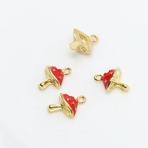 Detailed view of four red mushroom pendants with gold accents for DIY jewelry making
