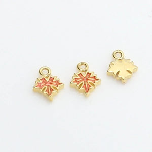 Detailed close-up of maple leaf pendants in gold plating with orange enamel finish
