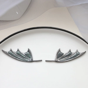 Detailed view of translucent dark dragon wing charms with green glitter for DIY jewelry making