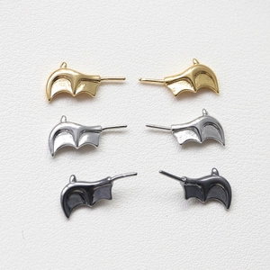 Gothic bat wing earrings in gold, silver and gun black finish on white leather texture