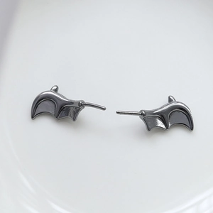 Macro view of gunmetal bat wing earrings with a polished finish for Gothic jewelry styles