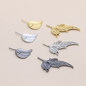 Detailed macro view of DIY wing charms in gold, silver, and black metal for jewelry making
