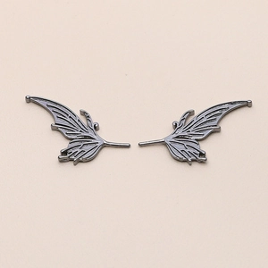 Detailed close-up of matte black butterfly wing metal charms with hollow filigree texture