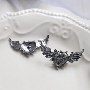Detail of angel wing heart stud earrings with cubic zirconia in vintage silver finish