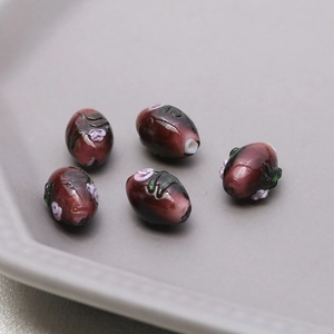 Macro shot of oval lampwork glass beads with embossed rose floral pattern for DIY jewelry