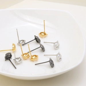 Minimalist cat-shaped stud earring set in gold, silver and black on ceramic plate