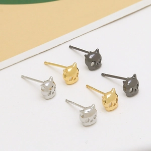 Detailed view of cat skull earrings in silver, gold, and gunmetal finishes on flat background