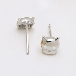 Macro view of silver cat skull earrings showing hollow design and secure stud back