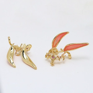 Detailed close-up of gold leaf-shaped components with pink enamel and red crystals