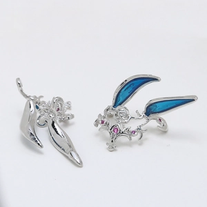 Detailed macro view of silver fantasy hollowed-out earring with blue enamel and red zircon