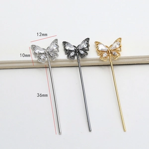 Macro view of butterfly zircon charms in silver, gun black and rose gold finishes