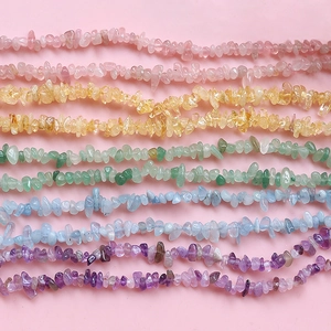 Colorful natural gemstone chip beads for DIY jewelry making on pink background