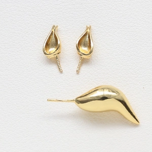 Macro shot of 18k gold plated baroque fox-themed DIY jewelry components on white leather