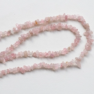 Detailed macro shot of irregular pale pink crystal quartz beads for DIY jewelry making