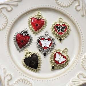 Gothic style heart pendants with rose and sword details on white porcelain plate