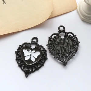 Detail of vintage heart charms with white butterfly motif and hollowed metal frame