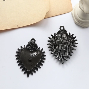 Detail of gothic rose heart alloy pendants with black enamel and spiked edges