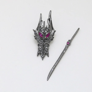 Detailed view of dragon-shaped mask jewelry set with pink crystal inlays in dark finish