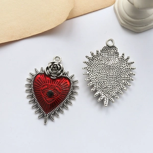 Detail of red enamel heart pendant with rose and eye motif showing front and back view
