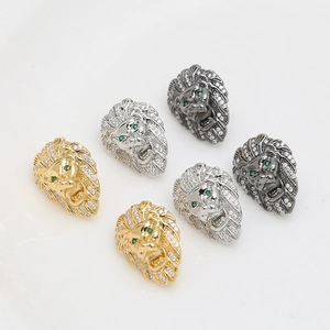 Detalle de dijes de cabeza de león con circonitas micro pavé y ojos de gemas verdes