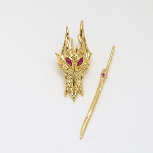 Detailed golden dragon head brooch with red gemstone eyes and matching long pin set