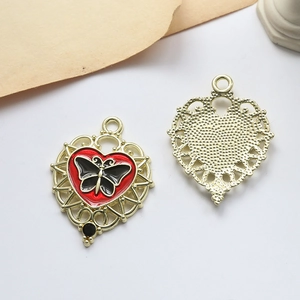 Detailed front and back of heart butterfly pendant with red enamel and gold finish