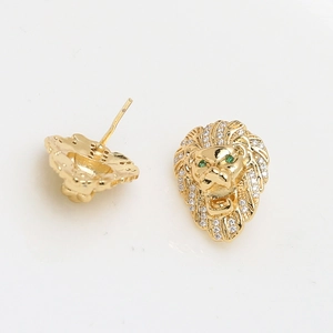 Detalle de pendiente cabeza de león dorado con circonitas blancas y ojos verdes