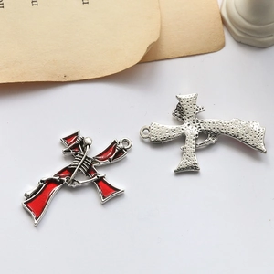Detailed front and back views of a Gothic red enamel cross pendant with skeleton detail