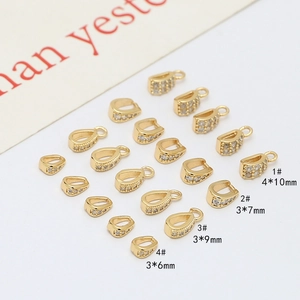 Gros plan d'attaches de pendentifs dorées avec oxydes de zirconium en quatre tailles variées