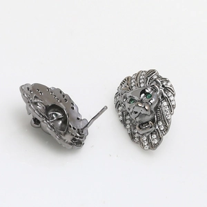 Detalle de pendientes de cabeza de león en acabado bronce con ojos de circón verde y cristales