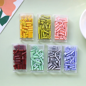 Flat lay of colorful striped tube beads in clear storage boxes for DIY jewelry making