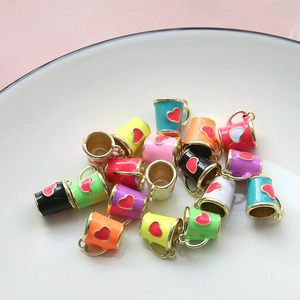 Dettaglio macro di mini ciondoli a forma di tazza colorata con cuori per gioielli fai da te