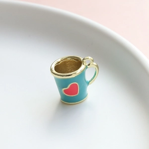 Dettaglio ciondolo a tazza in smalto blu con cuore e manico dorato per gioielli DIY