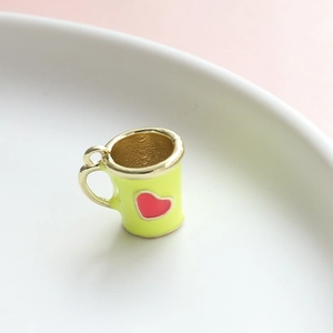 Dettaglio di un ciondolo a tazza verde con cuore rosso per la creazione di gioielli