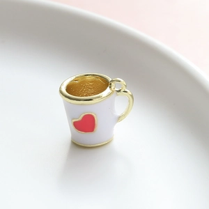 Dettaglio di un mini ciondolo a tazza con cuore e manico dorato per gioielli fai da te