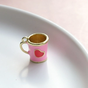 Dettaglio di mini tazza da caffè rosa con cuore rosso e finiture in metallo dorato