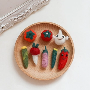 Handgefertigtes Wollfilz-Gemüse-Set mit Tomate und Aubergine auf einem Holztablett