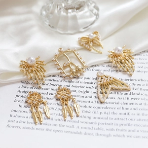 Golden pearl bow dreamcatcher charms on white satin and vintage book pages for DIY