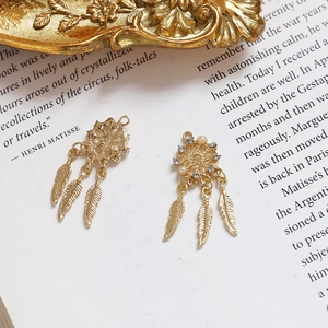 Macro view of golden dreamcatcher charms with pearls, rhinestones and feather details