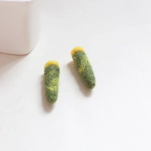 Detail handgefertigter grüner Filzanhänger mit gelben Punkten für DIY-Handwerk