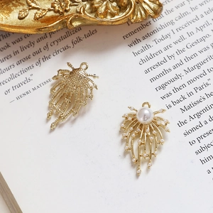 Macro detail of golden fishtail dreamcatcher charms with faux pearls on vintage book