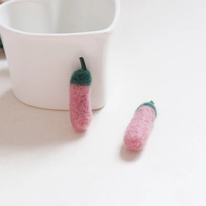 Nahaufnahme der rosa handgefertigten Wollfilz-Chilis für DIY-Schmuck und Haarschmuck