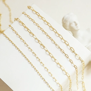 Cinque stili di catene in oro 14k esposte su un elegante piedistallo bianco raffinato