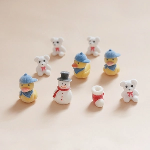 Vue à plat de breloques de Noël floquées avec ours, canard, bonhomme de neige et botte