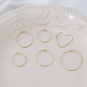 Macro shot of 14k gold-plated mixed round and heart-shaped earring hoop components